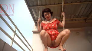 Depraved housewife waving on a swing outdoors